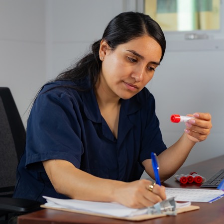 A research employee labels and tracks data for the vials she is holding.