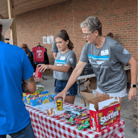 Pipestone team members volunteer at the McCrossan Boys Ranch Rodeo by handing out snacks and food at the event.