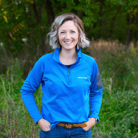 A picture of Dr. Cara Haden standing in a grassy area.
