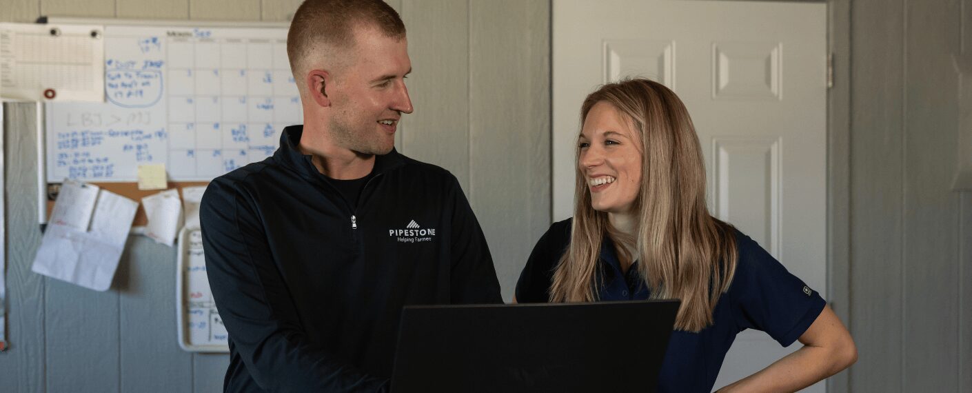 Two FarmBooks team members work together to create a financial plan for a swine producer