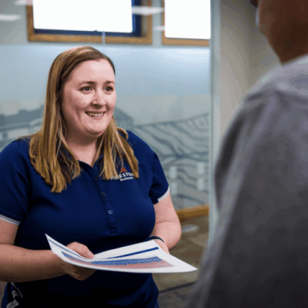A FarmStats team member hands another employee data for a swine farm's production.