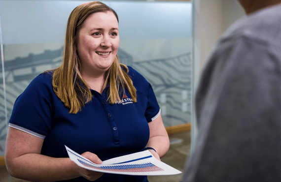 A FarmStats team member hands another employee data for a swine farm's production.