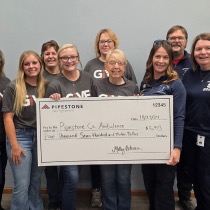 A group of pipestone volunteers and first responders stand holding a check.