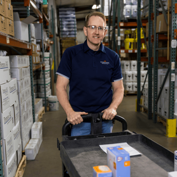An animal health warehouse worker collects products to be shipped to farms.
