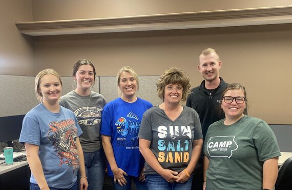A group of 6 FarmBooks employees take a group picture in the office.