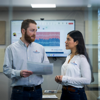 Team members standing in a meeting room talking over swine data.