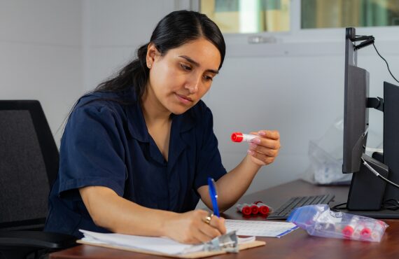 A research employee labels and tracks data for the vials she is holding.