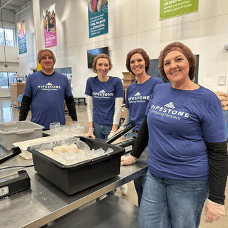 Four pipestone employees volunteering at a food preparing event.