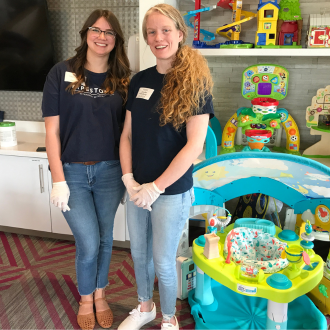 Two women stand in front of donated children's toys.