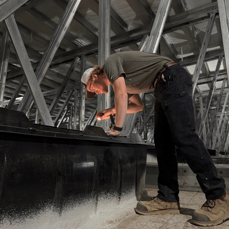 A construction team member reviews the filters within a sow farm.