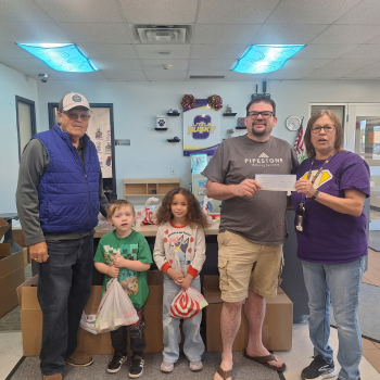 A sow farm manager delivers a check to a local charity.